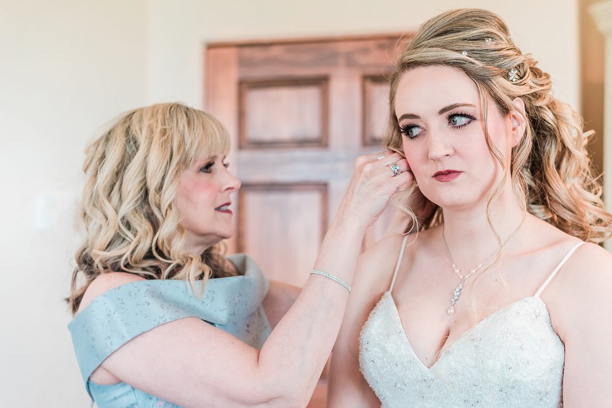 Bride's mom helps her put in her earrings